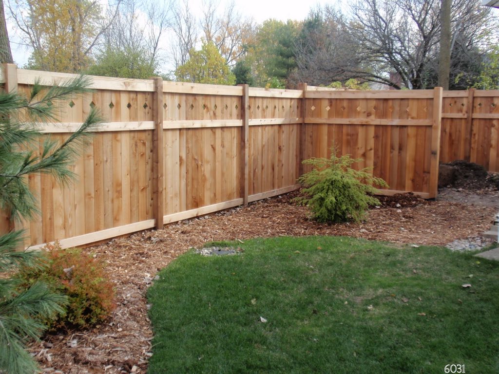 A fencing prject completed by Out Back Casual Living and Fence. A 6-foot tall fence surrounds and backyard with mulch and a rounded lawn.